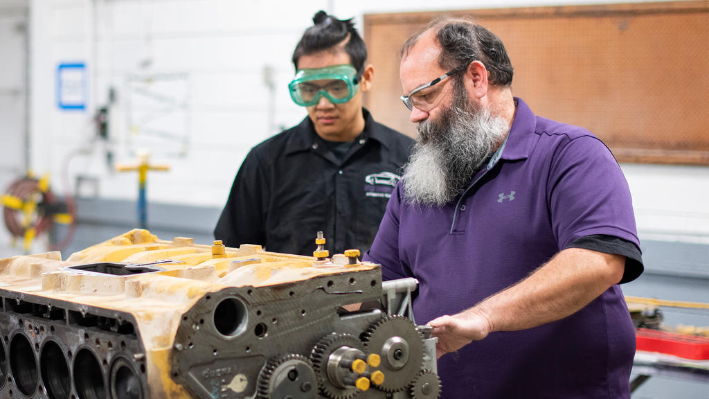 Diesel technology instructor and student examining engine